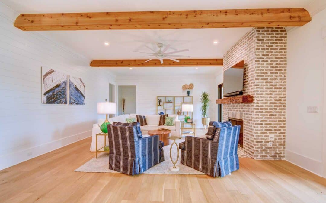 The main living area centers around a brick fireplace and massive wood beams overhead