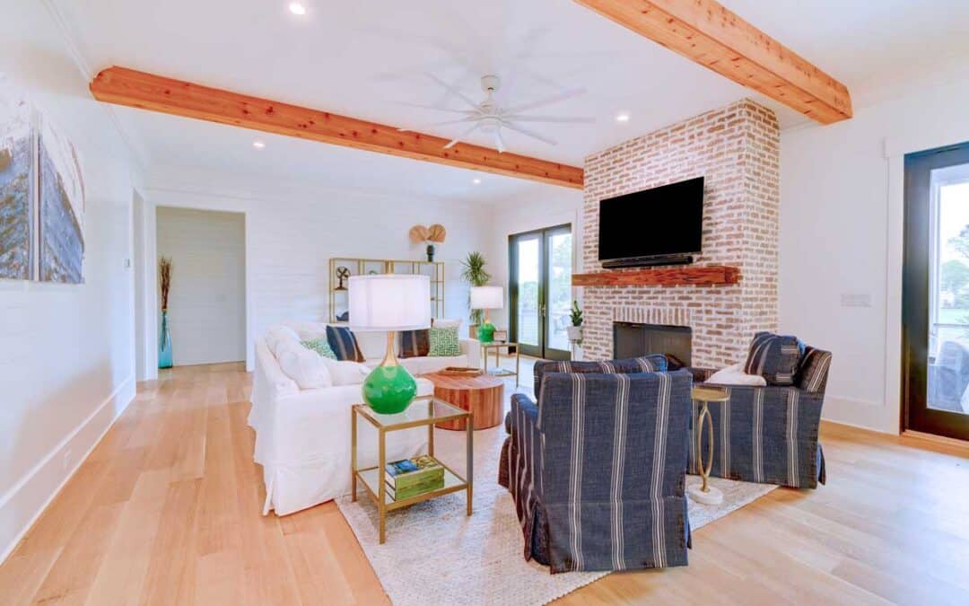 The main living area centers around a brick fireplace and massive wood beams overhead