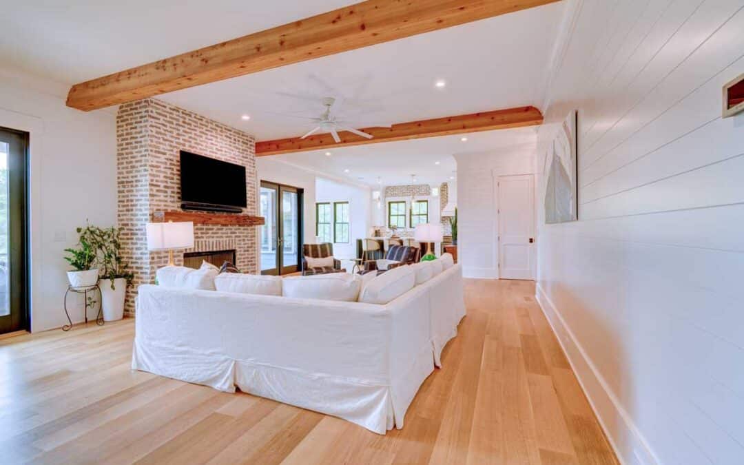 The main living area centers around a brick fireplace and massive wood beams overhead