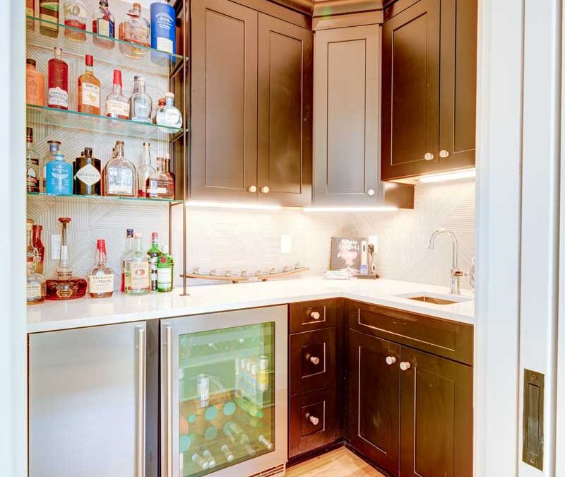 A custom pantry with cabinetry, wine cooler and wet bar